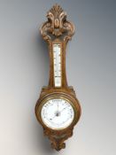 A carved oak aneroid barometer,