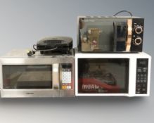 Three various microwaves and a sandwich toaster