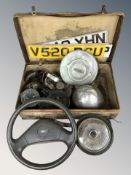 A group of automobile components including steering wheel, registration plates, lights, gauge, etc.