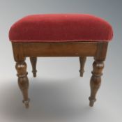 A mahogany stool in red upholstery, width 45 cm.