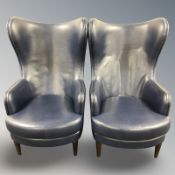 A pair of contemporary blue leather wingback armchairs, width 70 cm.