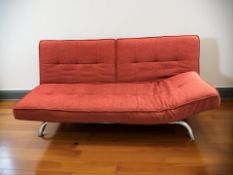 A 20th century day bed on chrome legs, with red fabric cushions, length 200 cm.