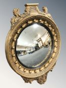 A Regency style gilt convex mirror, height 55 cm. CONDITION REPORT: Lacking pediment.