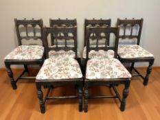 An early 20th century set of six oak dining chairs with floral seat pads.