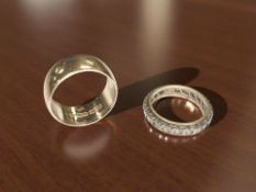 A 9ct gold band ring, size N, and a paste-set eternity ring.