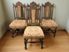 A set of four carved oak dining chairs in studded Burgundy fabric.