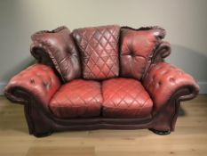 A Chesterfield style oxblood buttoned leather two seater settee, 170 cm W x 105 cm D x 102 cm H.