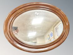 An early 20th century bevelled oval mirror, 77 cm x 55 cm.