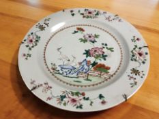 A 19th century Chinese tin glazed porcelain charger depicting storks in a garden,