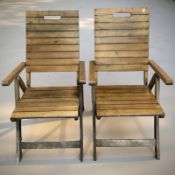 A pair of teak folding garden armchairs.