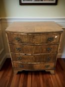 An early 20th century figured walnut bow front four drawer chest,