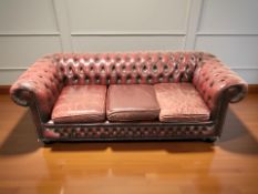 A Chesterfield oxblood leather three seater club settee,