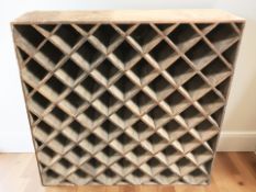 An early 20th century plywood wine rack, 107 cm x 31 cm x 105 cm.