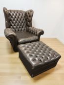 A Chesterfield brown buttoned leather wingback armchair and matching footstool, chair 105 cm W.