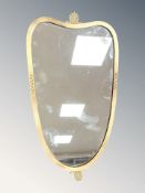 An early 20th century brass shield shaped mirror, 76 cm x 42 cm.
