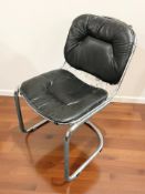 A Scandinavian chrome cantilever chair with black leather cushion and back rest.