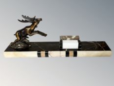 An Art Deco marble and gilt metal desk stand surmounted by a leaping deer, length 34 cm.