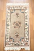 A Chinese fringed woolen rug, 170 cm x 77 cm.