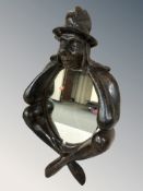 A Dutch carved and stained beech figural wall mirror, height 43 cm.