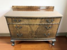 An early 20th century mahogany bow front three drawer chest on claw and ball feet,