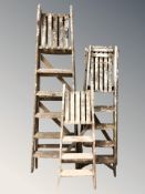 Three vintage wooden decorator's stepladders.