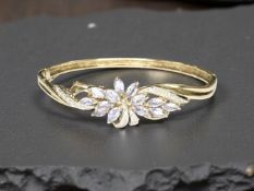 A 9ct gold tanzanite and diamond bangle, inner width 6cm. CONDITION REPORT: 11.