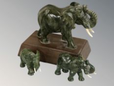 A group of carved malachite elephants, one on wooden stand, height 13 cm.