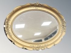 An early 20th century composition oval mirror, 89 cm x 66 cm.