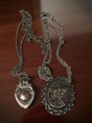 A Victorian silver locket on chain, and a silver motor club fob on chain won by F Hunter.
