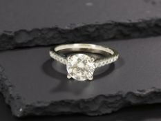 An 18ct white gold solitaire diamond ring, approximately 1ct, set with diamond shoulders,