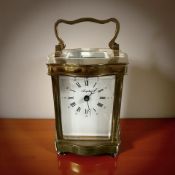 A French brass carriage timepiece with white enamel dial, signed Angelus,