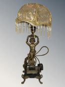 A gilt metal and black slate figural table lamp in the form of a cherub, with modern shade,