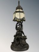 A figural table lamp with stained and leaded shade, height 46 cm.