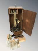 A lacquered brass microscope in carry case with lenses, together with a group of glass slides,