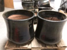 A pair of black glazed earthen ware garden planters,