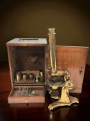 A lacquered brass microscope in carry case.