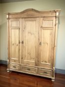 A contemporary pine triple door wardrobe, 174 cm x 67 cm x 212 cm.