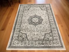 A machine made rug on grey ground, 233 cm x 161 cm.