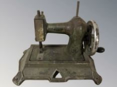 A small enameled metal sewing machine, width 25 cm.