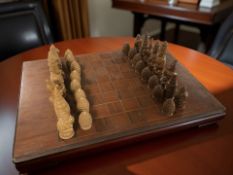 A stained teak chessboard and a set of resin oriental style chess pieces, kings 13 cm.