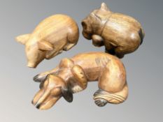 A carved wooden figure of a sleeping dog, a further pig and a hippo, largest 35 cm wide.