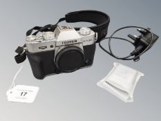 A Fujifilm X-T30 silver camera body, with two Fujifilm batteries, charger and camera strap.
