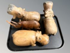 Three carved wooden figures of hippos and a further rhinoceros.
