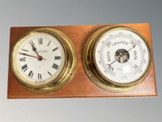 A ship's brass cased circular barometer and quartz timepiece, mounted on teak board, width 48 cm.