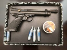 A Crosman .22 caliber PCP air pistol, tin of pellets and several CO2 canisters.