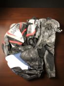 Three sets of motorcycle leathers.