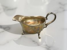 A silver cream jug, length 12cm.