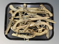 A group of flat backed brass flintlock pistol ornaments, similar knife in sheath.