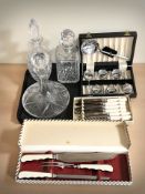A group of boxed cutlery, a ship's decanter and two further decanters.