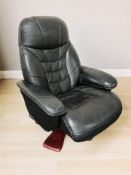 A black stitched leather swivel lounge armchair.